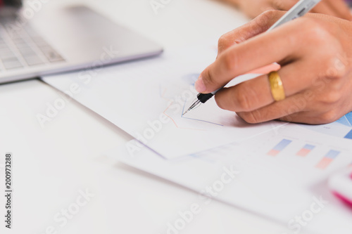Close up woman working at home office. yong businessmen calculate about cost and stock market or forex graph suitable for financial investment.