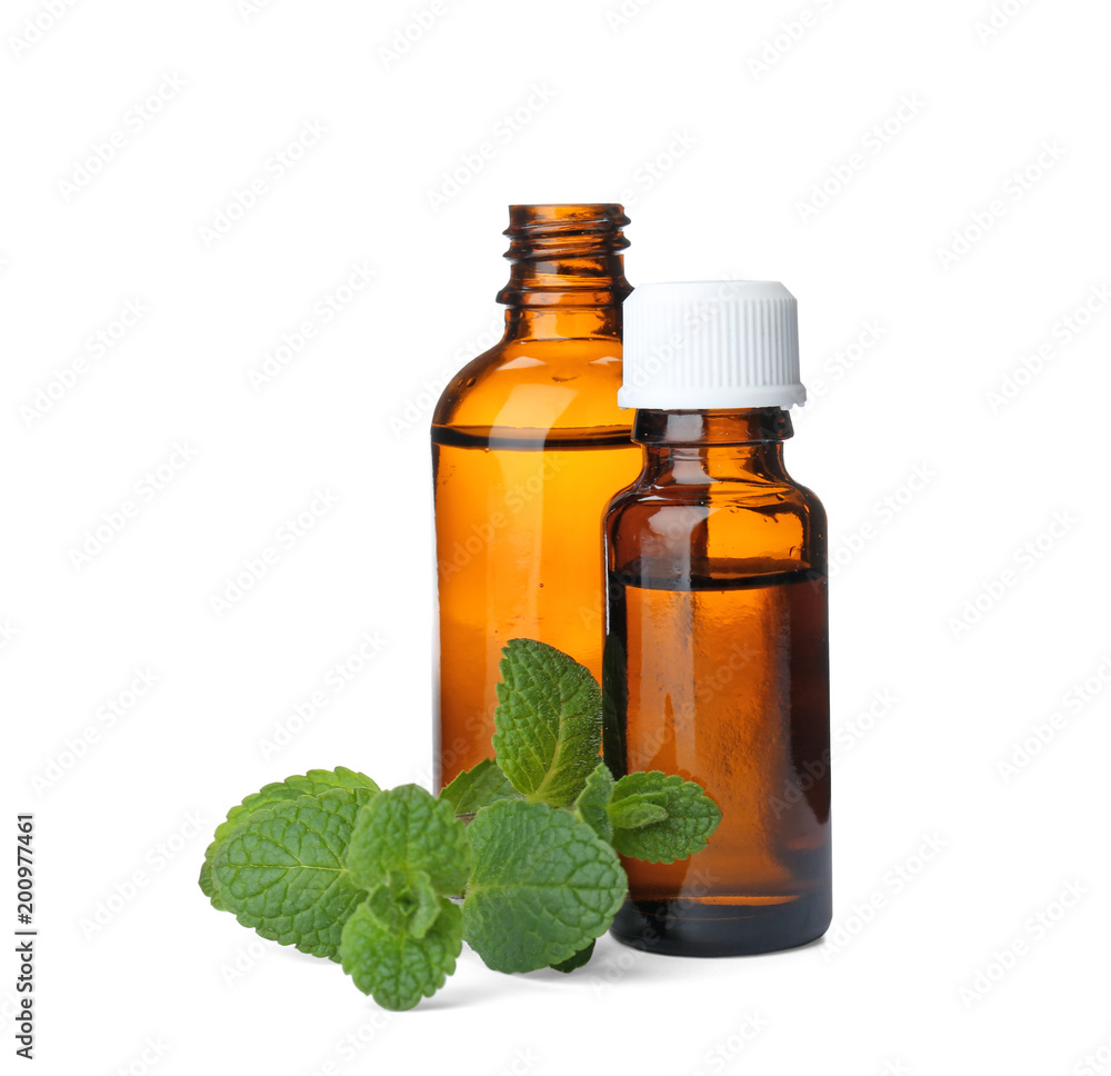 Bottles with mint essential oil and fresh herb on white background Bottles with mint essential oil and fresh herb on white background