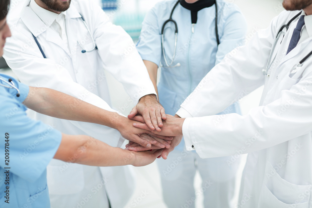 doctors holding hands together at hospital doctors holding hands together at hospital