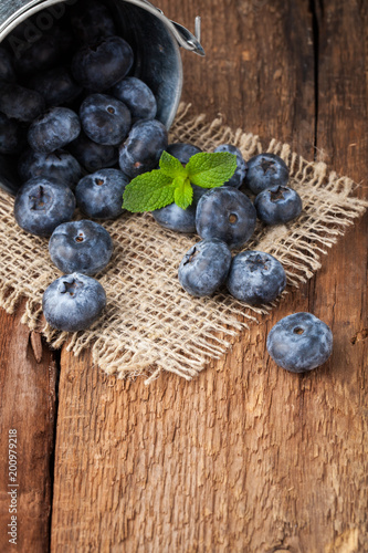 Blueberry on wooden table background. Ripe and juicy fresh picked blueberries closeup. Berries closeup with copy space