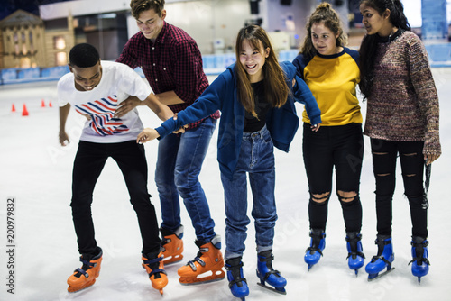 Group of teenage friends ice skating on an ice rink