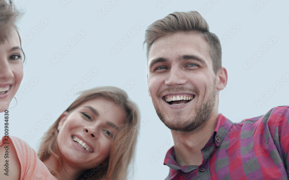 closeup of three young people smiling on white background closeup of three young people smiling on white background