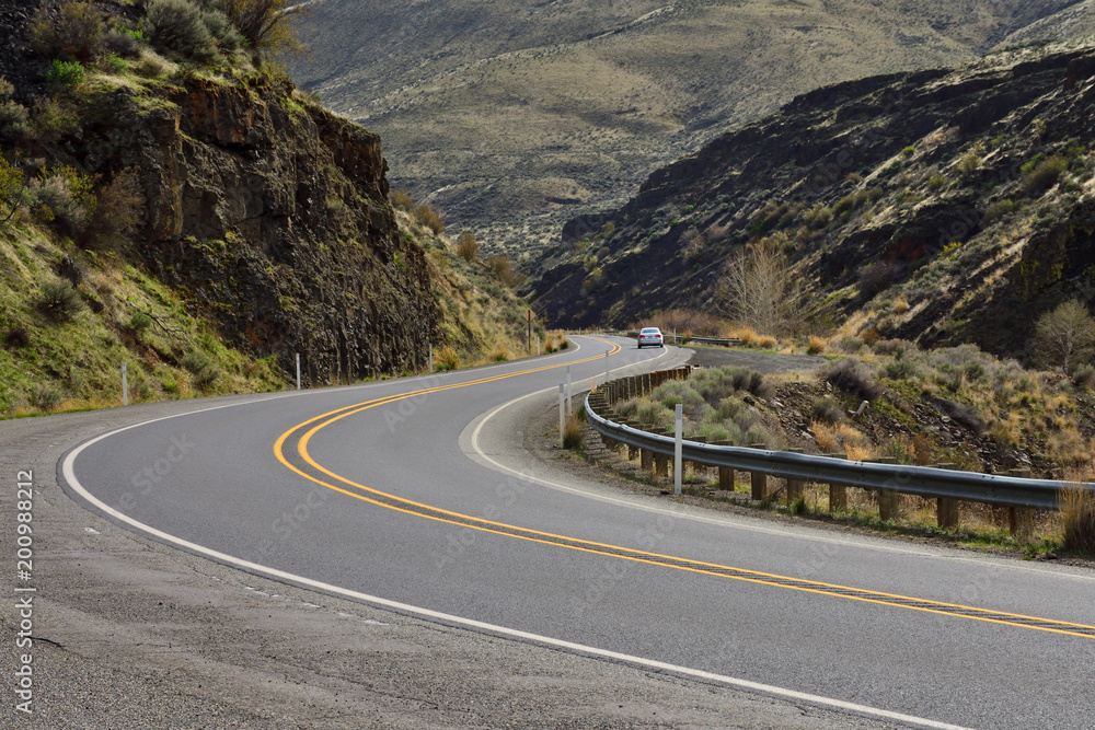 A car passing through the Yakima River Canyon Road