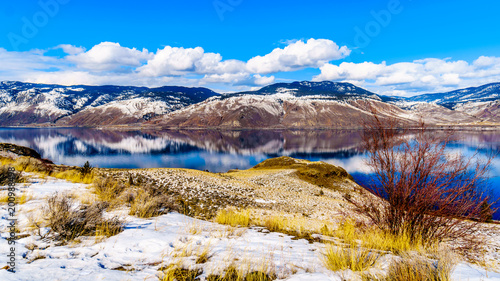 Snow Covered Mountains surrounding Kamloops Lake in central British Columbia  Canada on a cold and crisp Winter Day under a blue sky