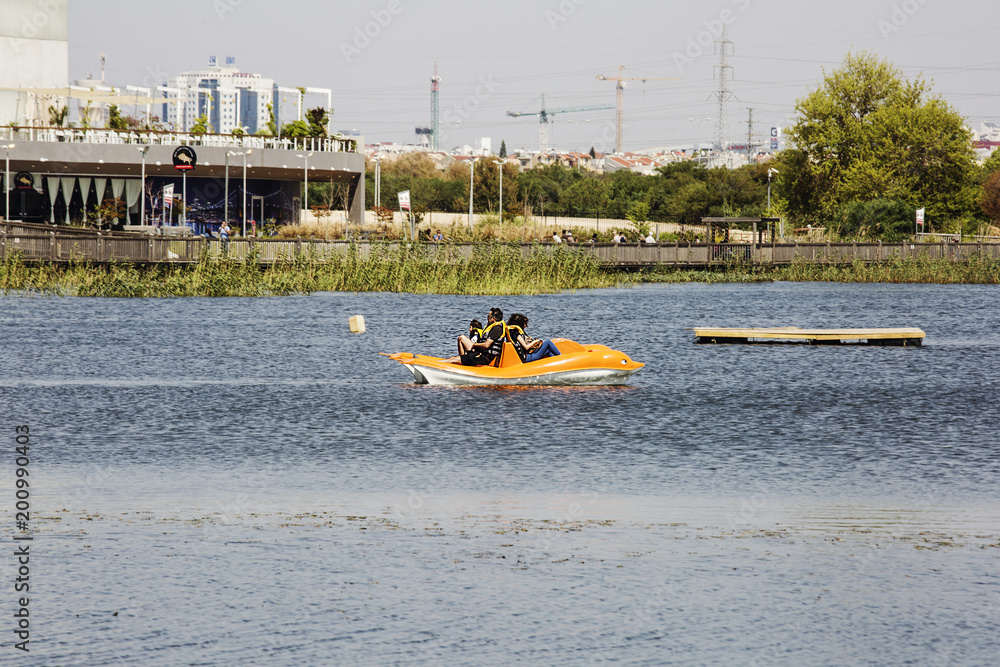 Obraz premium RISHON LE ZION, ISRAEL -APRIL 14, 2018: People ride on pedal boats or paddle boats at the lake in Rishon Le Zion, Israel