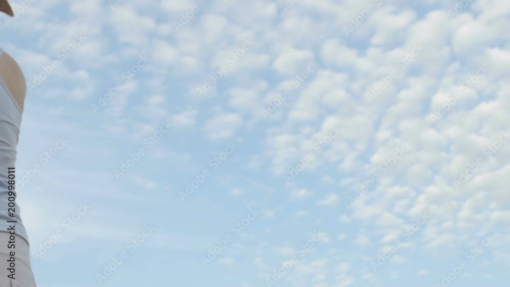 Lady serving tennis ball on clouds background, individual training for beginner Lady serving tennis ball on clouds background, individual training for beginner