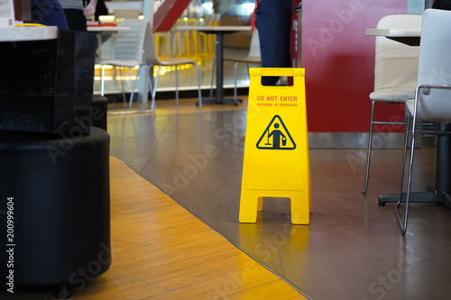 Yellow sign that alerts for wet floor in  the restaurant