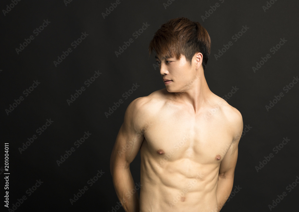 muscular young man isolated on black background