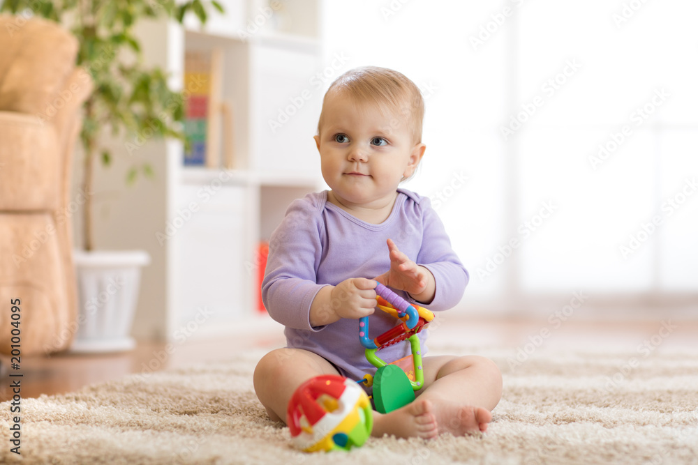 Smart baby girl with educatinal toys in sunny nursery room Smart baby girl with educatinal toys in sunny nursery room