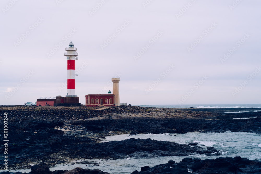 Toston Lighthouse at coastline against sky