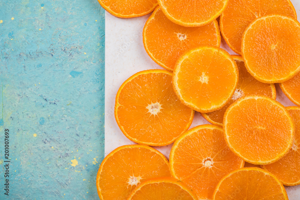 Orange slices on marble board and blue table Orange slices on marble board and blue table