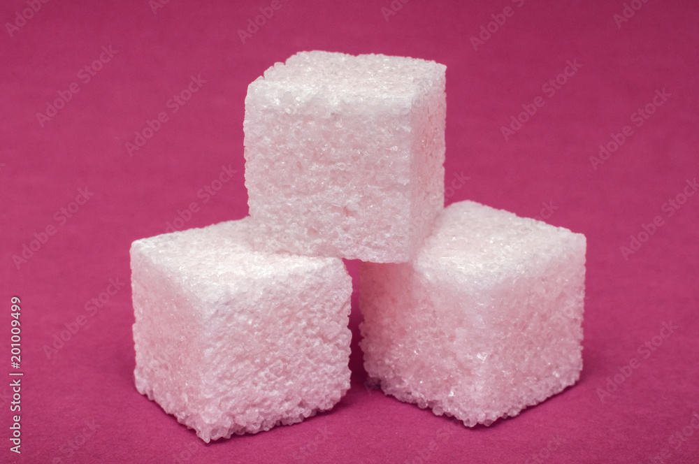 macro shot of a 3 cubes of sugar on a colored surface macro shot of a 3 cubes of sugar on a colored surface