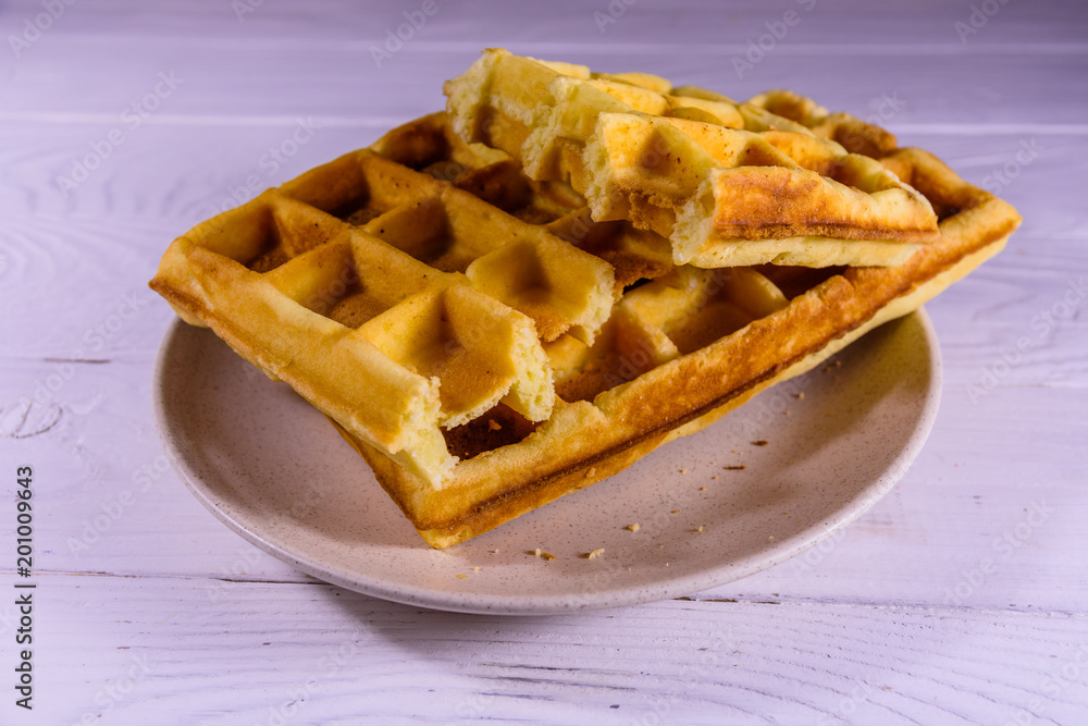 Ceramic plate with belgian waffles on wooden table Ceramic plate with belgian waffles on wooden table
