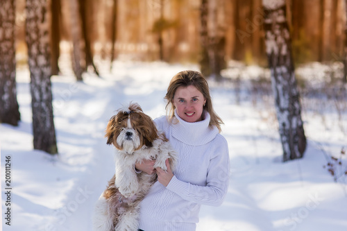 Outdoors lifestyle close up image of stunning woman hugging dog in the winter park.