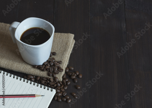 A cup of coffee and a notepad with pencil