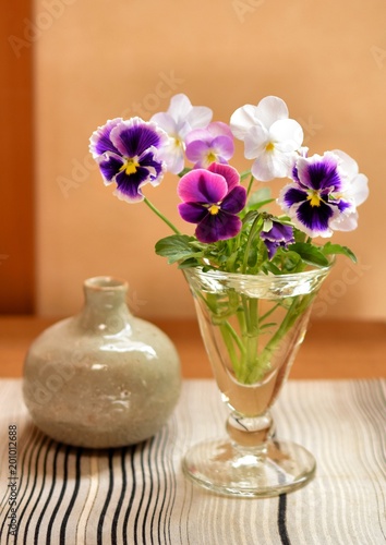 花瓶に入れたカラフルなビオラの花、和室