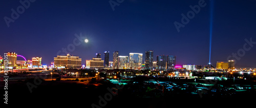A view of the Las Vegas skyline with a full moon shining down.