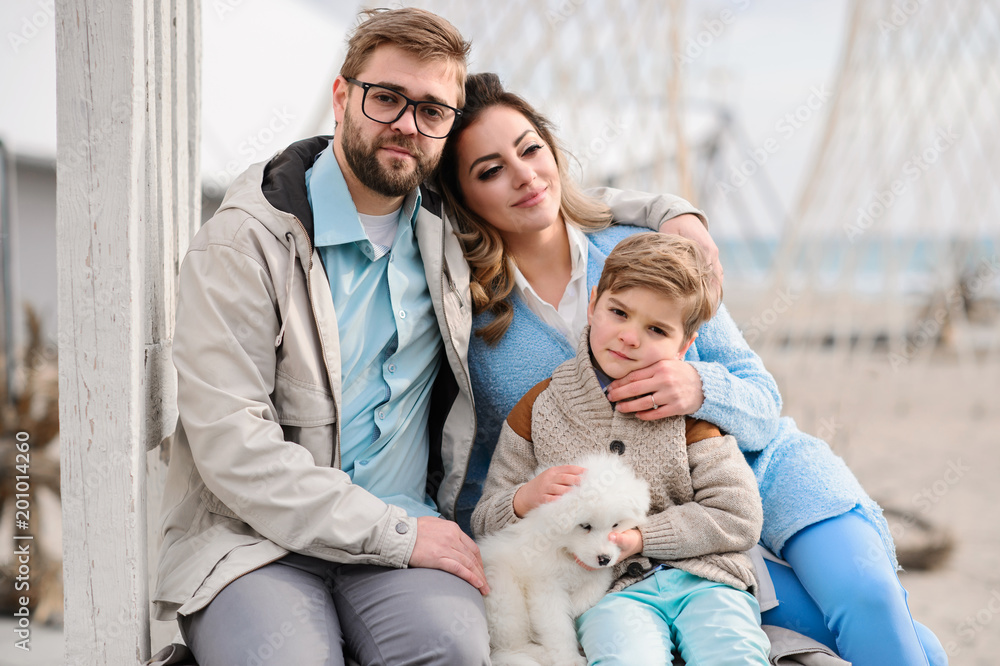 Happy family on a beach. The family walks on a beach with a dog. Happy family on a beach. The family walks on a beach with a dog.