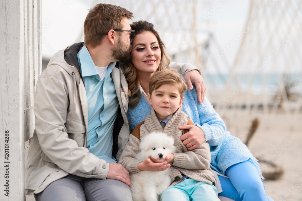 Happy family on a beach. The family walks on a beach with a dog. Happy family on a beach. The family walks on a beach with a dog.