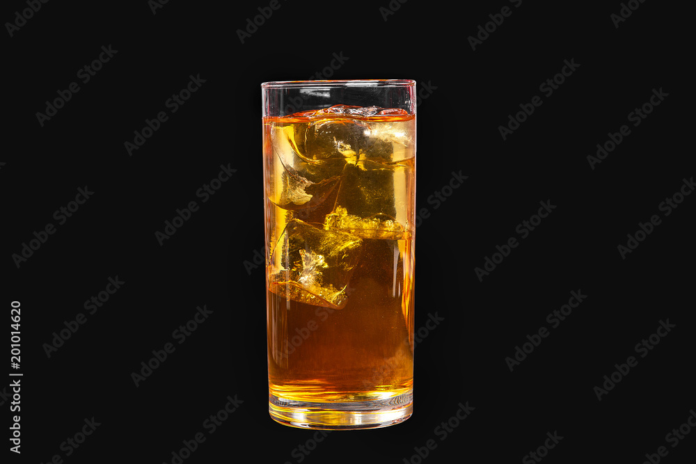 A single-colored transparent cocktail, refreshing in a tall glass with ice cubes with the taste of pear, melon, apple, apricot, peach. Side view Isolated black background. Drink for the menu A single-colored transparent cocktail, refreshing in a tall glass with ice cubes with the taste of pear, melon, apple, apricot, peach. Side view Isolated black background. Drink for the menu