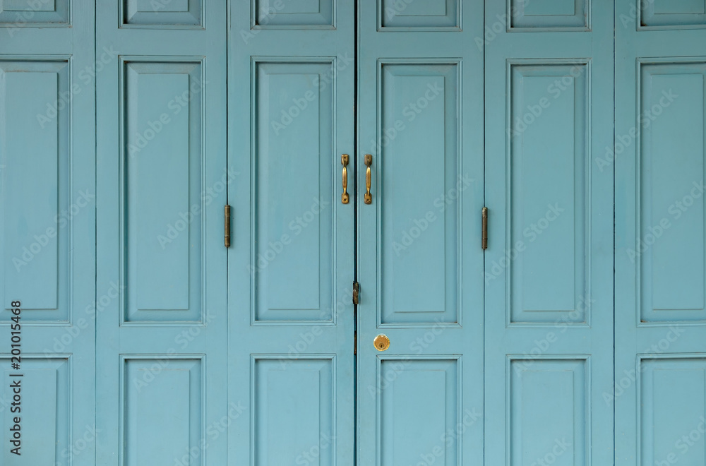 Antique golden Doors locked on blue old door. Antique golden Doors locked on blue old door.
