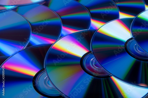 Many musical compact discs with a rainbow spectrum of colors as a bright background