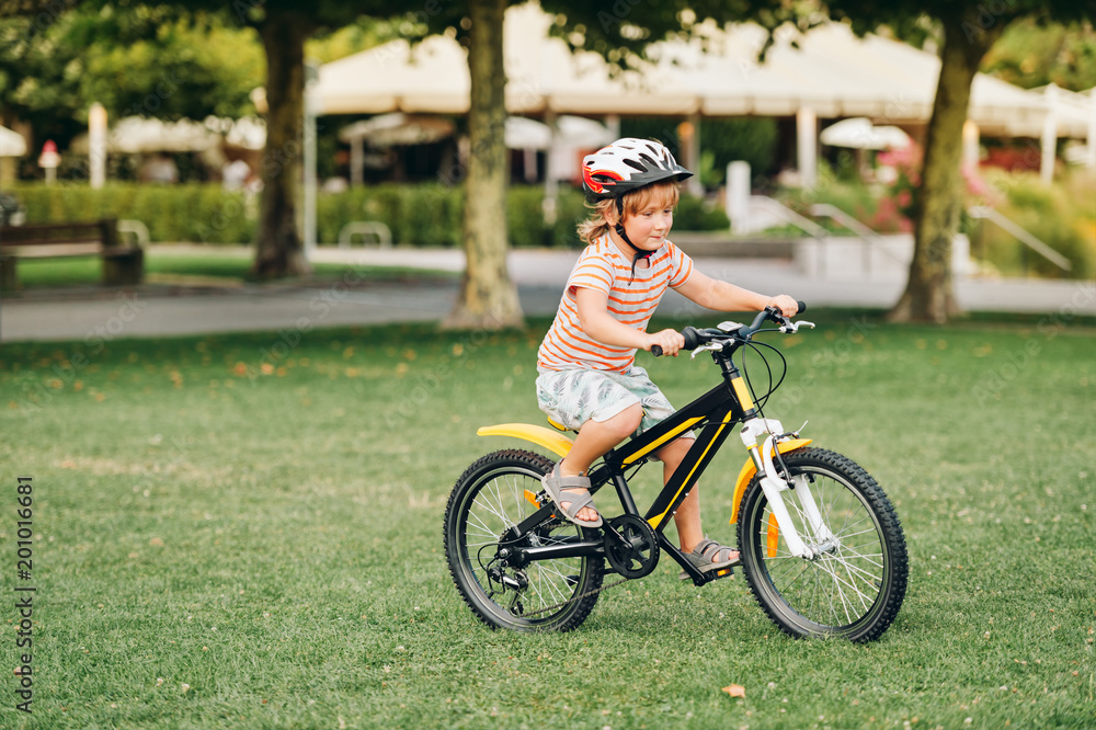 Cute little boy riding bicycle in the park, sport for children, active family outside