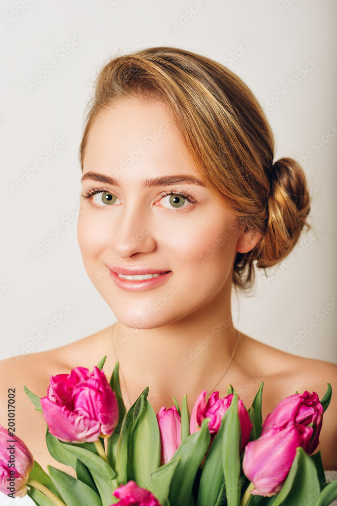 Studio shot of young beautiful girl with purple tulip flowers