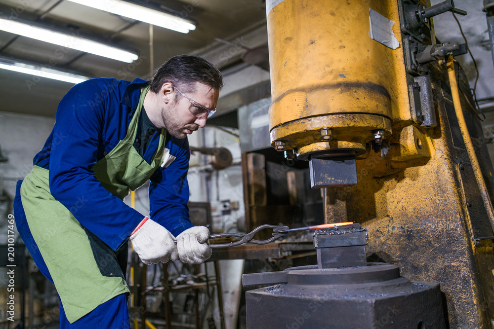 A brutal man works in a workshop