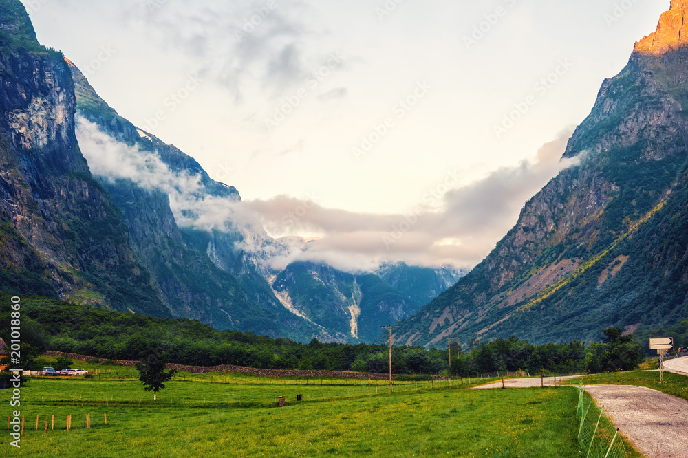 Obraz premium Beautiful views of the sunrise over the fjord and mountains from the bridge in the Norwegian village of Gudvangen.