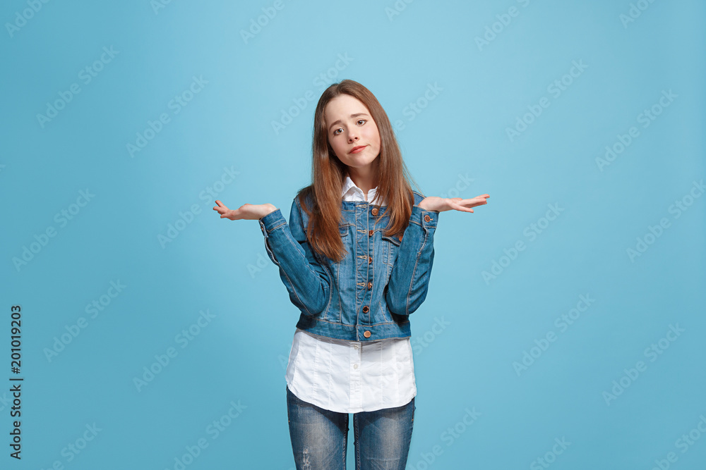 Beautiful teen girl looking suprised and bewildered isolated on blue Beautiful teen girl looking suprised and bewildered isolated on blue