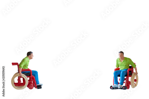 Miniature people Man in wheelchair  isolate on white background with clipping path © Sirichai Puangsuwan