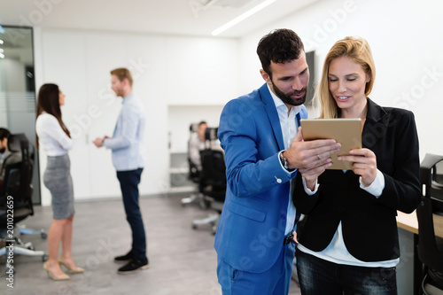 Attractive business couple using tablet in their company