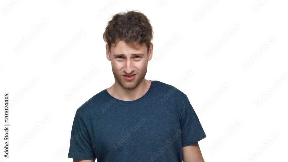 Portrait of impudent guy in t-shirt being aggressive and swearing with irritation, isolated over white background. Concept of emotions Portrait of impudent guy in t-shirt being aggressive and swearing with irritation, isolated over white background. Concept of emotions