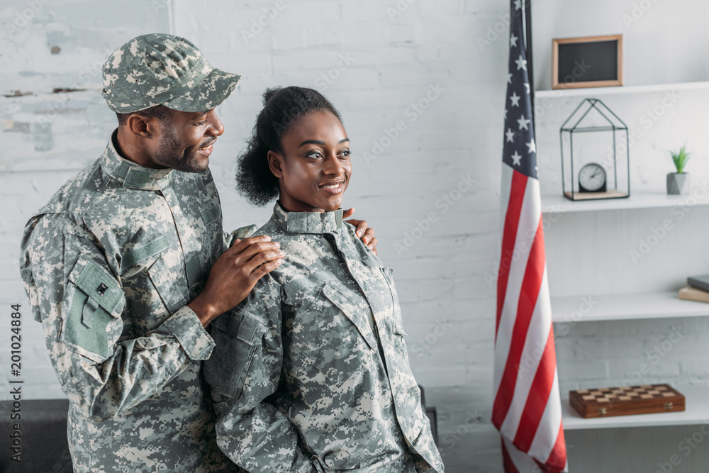 Fototapeta premium African american male soldier embracing woman in camouflage clothes