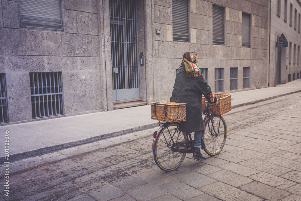 Obraz premium Healthy transport concept. Woman rides a vintage city bike on Italian street.