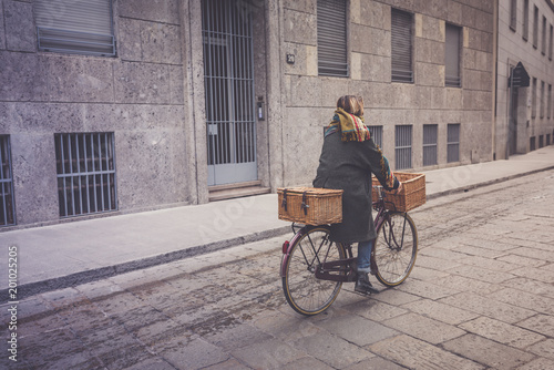 Healthy transport concept. Woman rides a vintage city bike on Italian street.