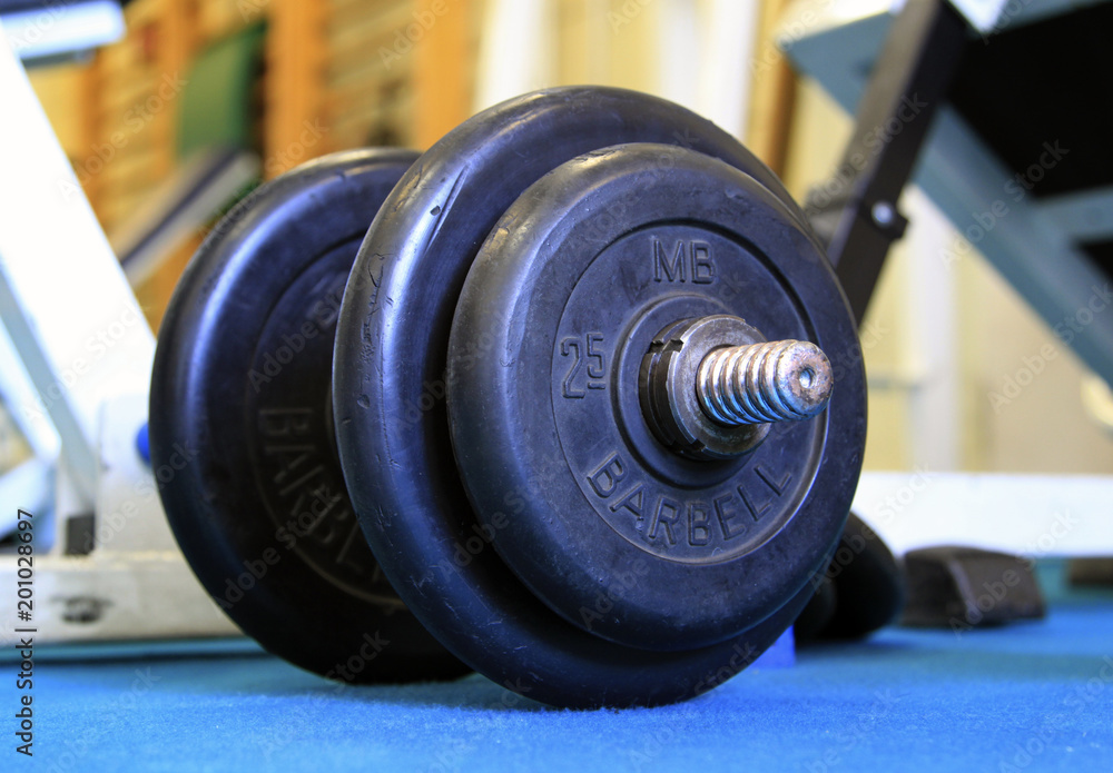 Close up of dumbbell and barbell on the floor at fitness gym