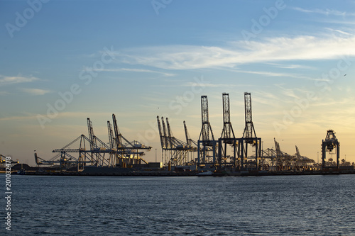 Sunset and gradient blue sky on the cranes of the biggest European seaport, Rotterdam, Netherlands