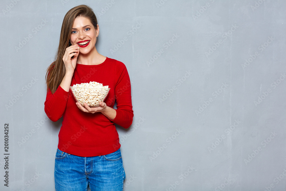 Young woman wearing red shirt eating pop corn.