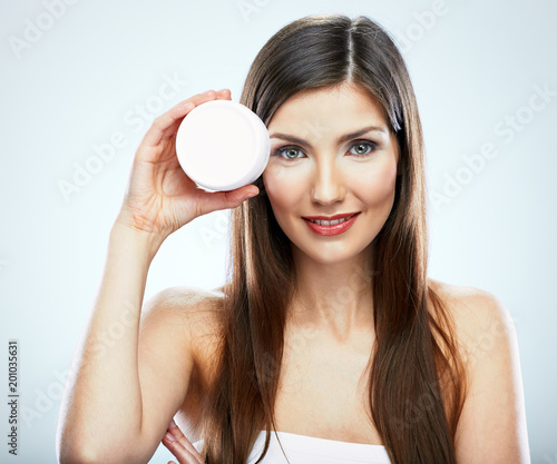 Beauty portrait of smiling girl holding skin cream.