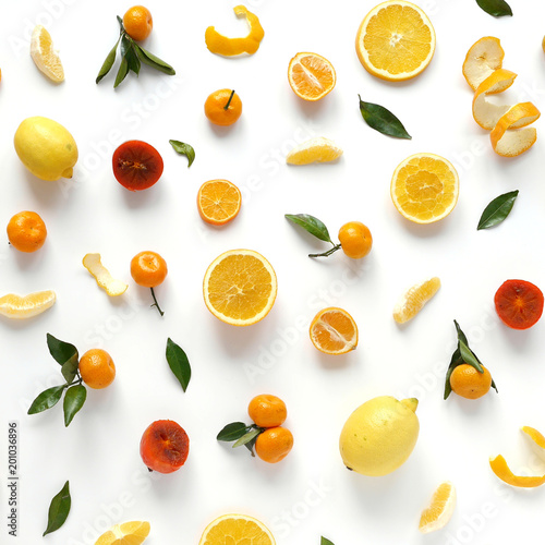 Creative flat layout of fruit, top view. Sliced orange, lemon, persimmon, tangerine, green leaves isolated on white background. Food wallpaper, composition pattern of fresh fruits.