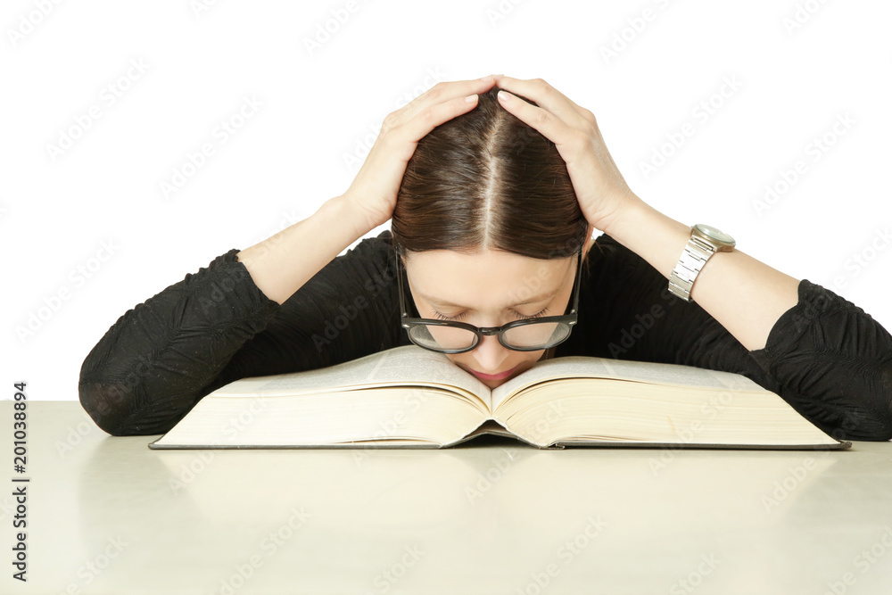 Studio portrait of young woman in front of big book on the table, don't feel like studying concept Studio portrait of young woman in front of big book on the table, don't feel like studying concept