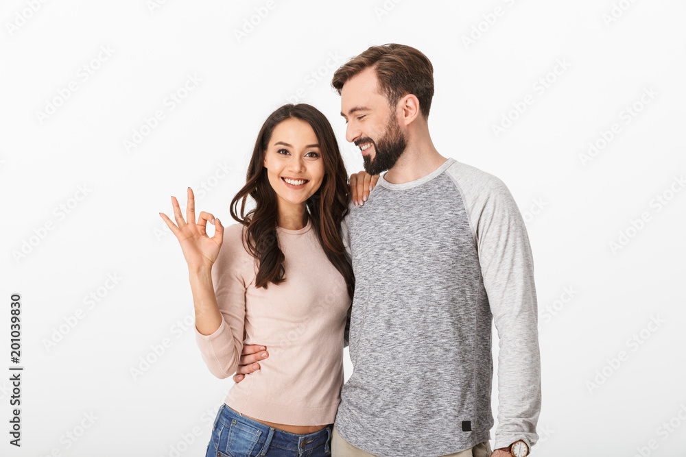 Happy young loving couple make okay gesture.