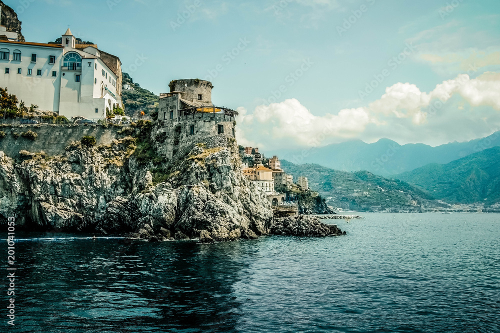Small haven of Amalfi village with tiny beach and colorful houses, located on rock, Amalfi coast with Gulf of Salerno, Campania, Italy.
