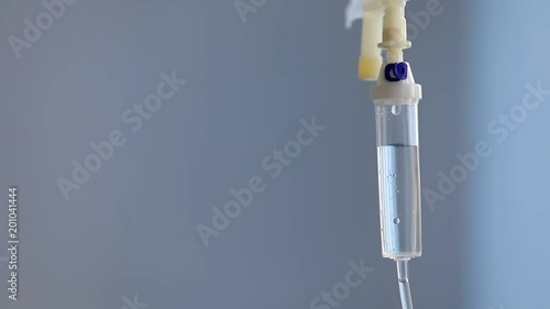 close up of a slow intravenous drip with a blurred blue background photo