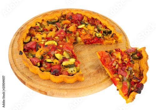 Roasted vegetable savoury pastry tart on a wooden cutting board isolated on a white background