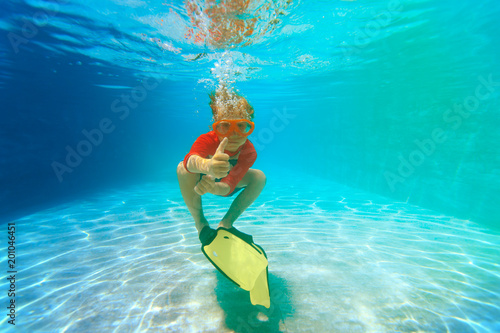 happy little boy swim underwater with thumbs up