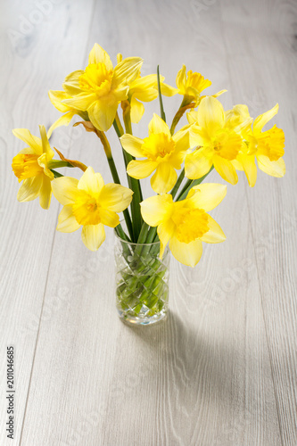 Fototapeta Naklejka Na Ścianę i Meble -  Bouquet of yellow daffodils in vase on wooden desk