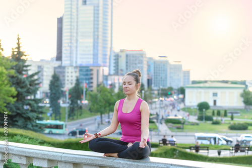 Young woman practicing yoga in urban environment photo